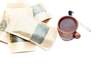 Cup of herbal healthy tea and bags with herbs close-up