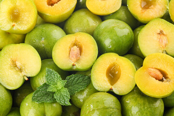 Fresh Green Plums Cut in Half with Mint Leaves - Healthy Organic Stone Fruit Supply