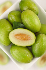 Fresh Green Chaoshan Olives in Bowl - Traditional Chinese Sweet Fruit with Orange Pit