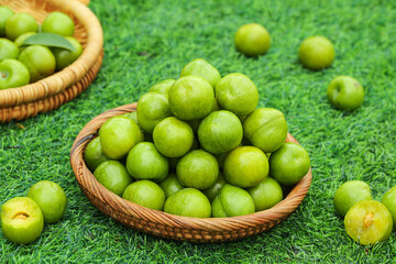 Fresh Green Sichuan Plums in Wicker Baskets on Grass - Organic Fruit Harvest