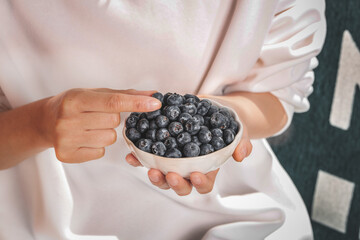 Fresh Blueberries in White Bowl Held by Woman - Healthy Organic Fruit for Tea Time