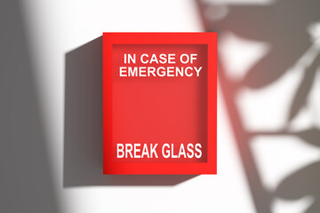 Emergency box hanging on white wall with break glass sign