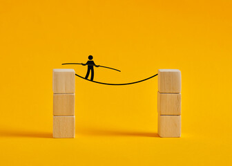 Businessman walking a tightrope between two stacks of blocks