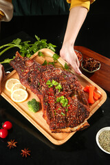 Grilled Lamb Chops with Herbs on Wooden Board - Chef Presenting Barbecue Meat with Fresh Parsley...