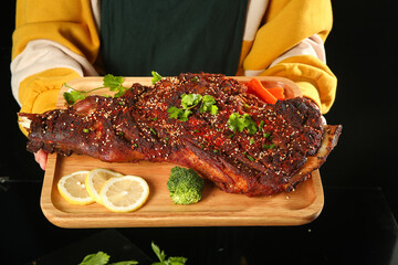 Grilled BBQ Ribs on Wooden Board with Fresh Herbs and Lemon Garnish