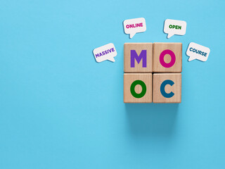 Massive open online course concept with wooden cubes and speech bubbles on blue background