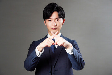 ビジネスマン　ばつ印のジェスチャー　黒背景