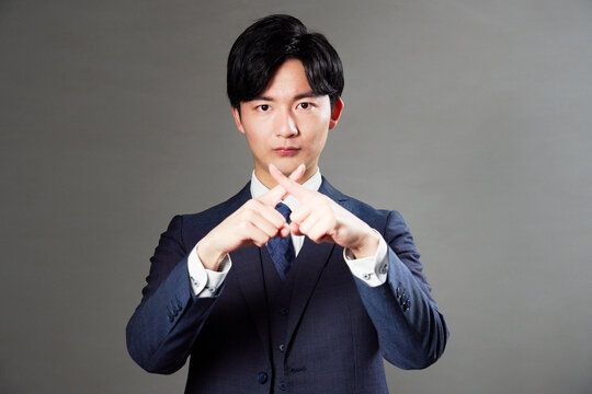 ビジネスマン　ばつ印のジェスチャー　黒背景