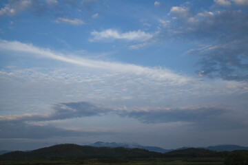 Blue Sky with White Clouds Over Green Hills and Mountain Range Landscape