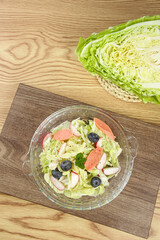 Fresh Coleslaw Salad with Vegetables and Blueberries in Glass Bowl on Wood Background