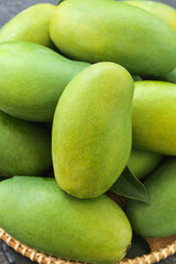 Fresh Green Mangoes in Wicker Basket - Tropical Fruit Closeup with Natural Texture