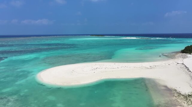 Aerial view of a serene tropical island with a pristine white sandy beach meeting the turquoise waters, Naavaidhoo, Haa Dhaalu Atoll Maldives.