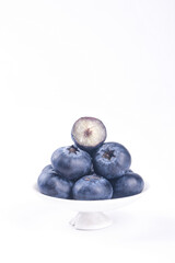 Fresh Organic Blueberries in White Bowl with Cut Half Showing Interior on White Background