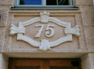 Numéro 75. Plaque de numéro de rue en relief et en plâtre.