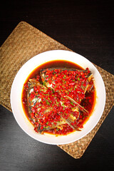 Steamed Whole Fish with Spicy Red Chili Sauce and Herbs on Bamboo Placemat