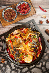 Spicy Asian Fish Head Casserole with Soy Sauce and Chili Peppers in Cast Iron Pot