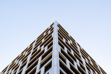 Modern residential building with stacked balconies and clean geometric design rising against a...