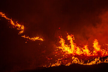 Firefighter battles a massive wildfire at night
