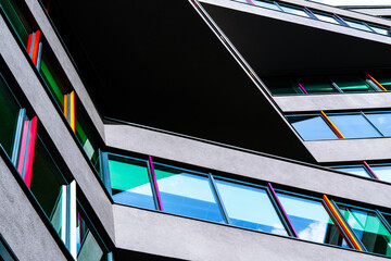 Modern building with colorful glass panels and sharp geometric lines creating dynamic architectural...