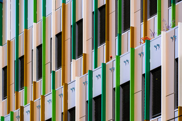 Colorful office façade with vertical green and yellow panels adding rhythm, contrast, and...