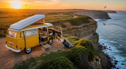 Yellow VW campervan parked on a cliff edge at sunset, overlooking the ocean.