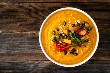 Pumpkin cream soup on wooden table