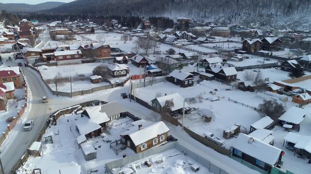 Aerial shot of Listvyanka village, Siberia Russia in winter. Traditional wooden architecture on Baikal lake shore, snowy pier, Trans-Siberian railway stop, tourism destination, travel culture. 4k