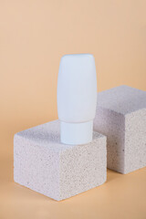 Cosmetic product in tube, bottle, lotion or serum with stylish props on cream background. 