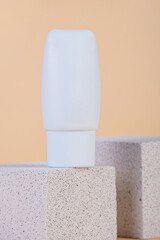 Cosmetic product in tube, bottle, lotion or serum with stylish props on cream background. 