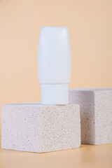 Cosmetic product in tube, bottle, lotion or serum with stylish props on cream background. 