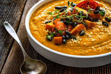 Pumpkin cream soup on wooden table