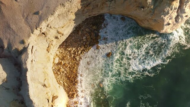 Aerial view of the rugged cliffs meeting the turquoise ocean waters in a stunning display of natural beauty, Port Willunga, South Australia, Australia.