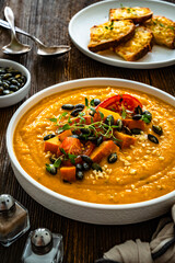 Pumpkin cream soup on wooden table