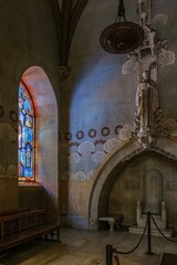 Beautiful Stained Glass Window Illuminates Gothic Stone Archway in Historic Religious Interior. Colorful religious artwork, Montserrat site, Catalonia