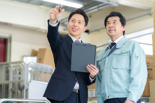 倉庫で仕事をする作業員とビジネスマン