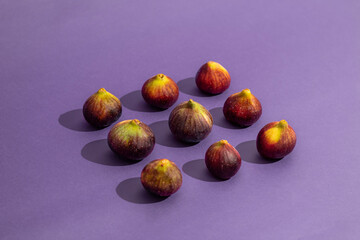 Pattern made of fresh figs on purple background. Flat lay, top view. Food Photo. Creative scheme of...