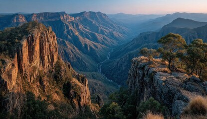 Majestic mountain landscape bathed in the warm glow of sunrise casting long shadows across the valley below