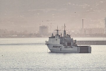 Spanish Navy amphibious ship Galicia anchored in Málaga, Spain. Coastal buildings and port visible in the background during naval operations