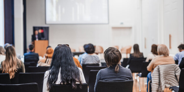 Speaker giving a talk in conference hall at business event. Rear view of unrecognizable people in audience at the conference hall. Business and entrepreneurship concept