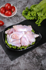 Fresh Raw Chicken Wings on Slate Board with Vegetables Ready for Cooking