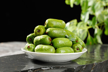Fresh Green Kiwi Fruits in White Bowl on Slate Surface with Natural Background