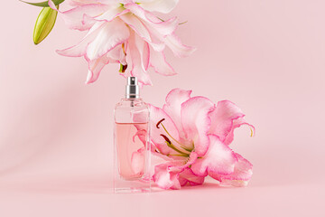 Perfume bottle and lily flower on pink background