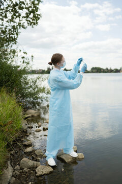 Young biologist studying water samples at lakeside