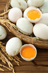 Fresh White Duck Eggs with Golden Yolks in Rustic Wicker Basket on Wood Table