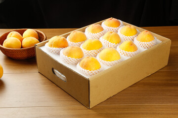 Golden Yellow Peaches in Gift Box Display with Sweet Fresh Fruit Packaging on Wood Table