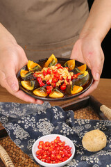 Chef Hands Presenting Traditional Asian Seafood Dish with Mussels Eggs and Colorful Vegetables in Restaurant Kitchen