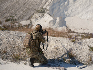Ukrainian Soldier Kneeling and Aiming in a Chalk Quarry