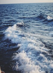 Fototapeta premium Foamy wake of a boat on deep blue ocean