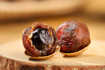 Dried Longan Fruit Cut in Half Showing Flesh and Seed on Wooden Board - Traditional Asian Food...
