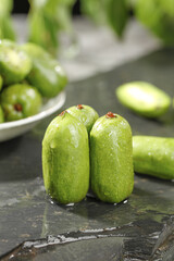 Fresh Baby Kiwi Fruits with Water Droplets on Rustic Wooden Surface